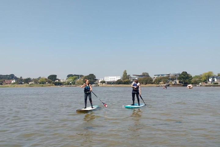 a group of people standing next to a body of water