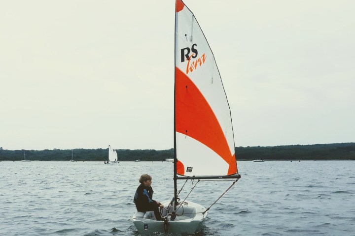 a man riding on the back of a boat in a body of water