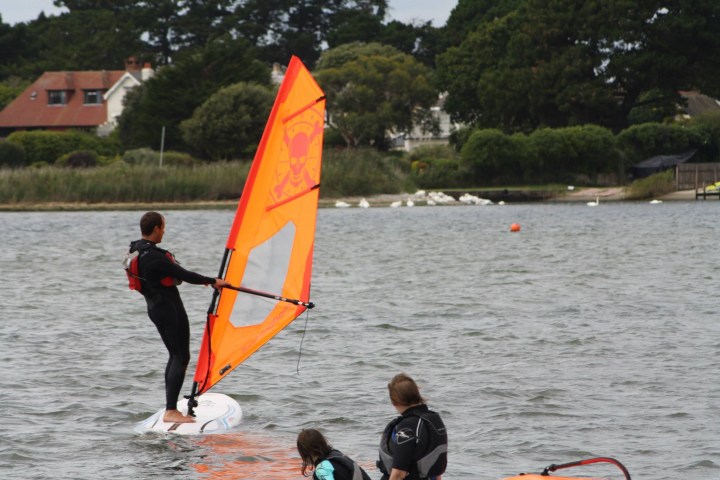 a man holding a kite in a large body of water