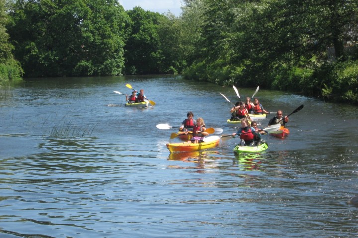 a group of people rowing a boat in a body of water