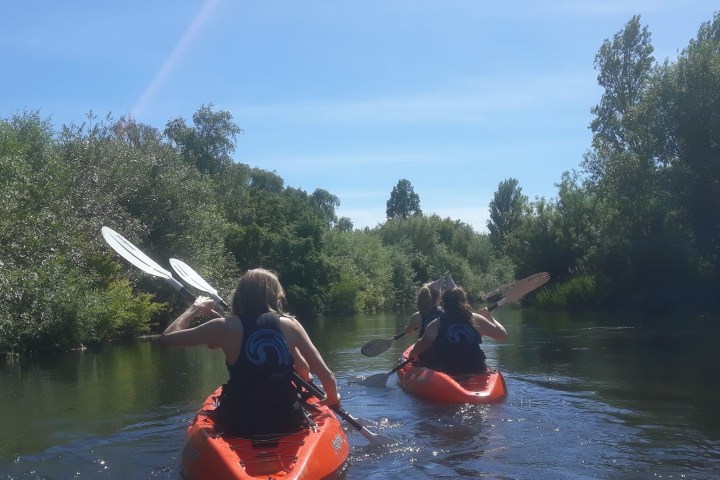 a group of people riding on the back of a boat in the water